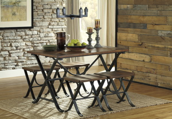 The Freimore dining table with matching stools is the perfect way to bring the outdoors in. This rustic dining room set features a picnic inspired metal frame, topped with a pine veneer tabletop with large recessed nail accents. Learn more at woodstockoutlet.com.