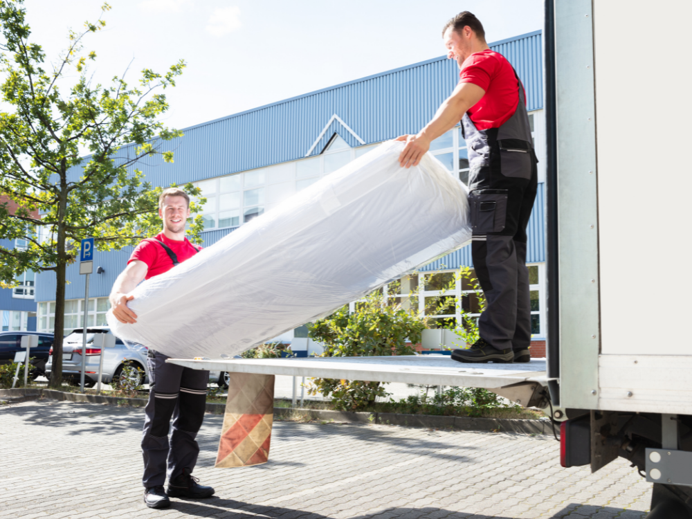 workers unloading and delivering a flat mattress foundation