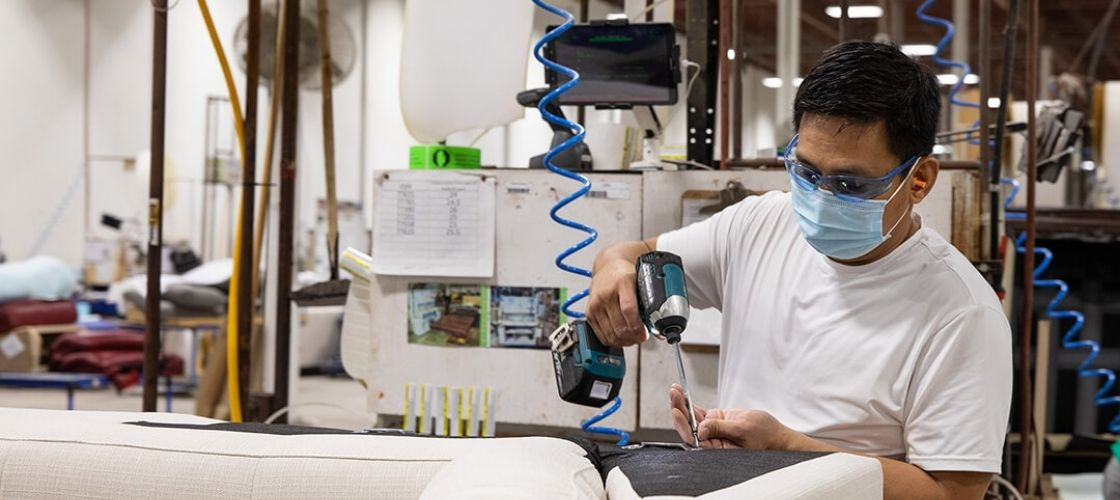 man at the Palliser factory assembling a sofa or sectional