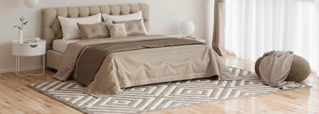 king size bed with beige comforter set sitting on a properly placed rug in bedroom
