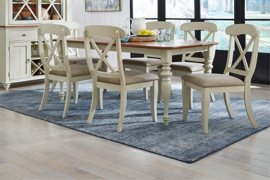 blue rug placed in dining room under white dining table and chairs