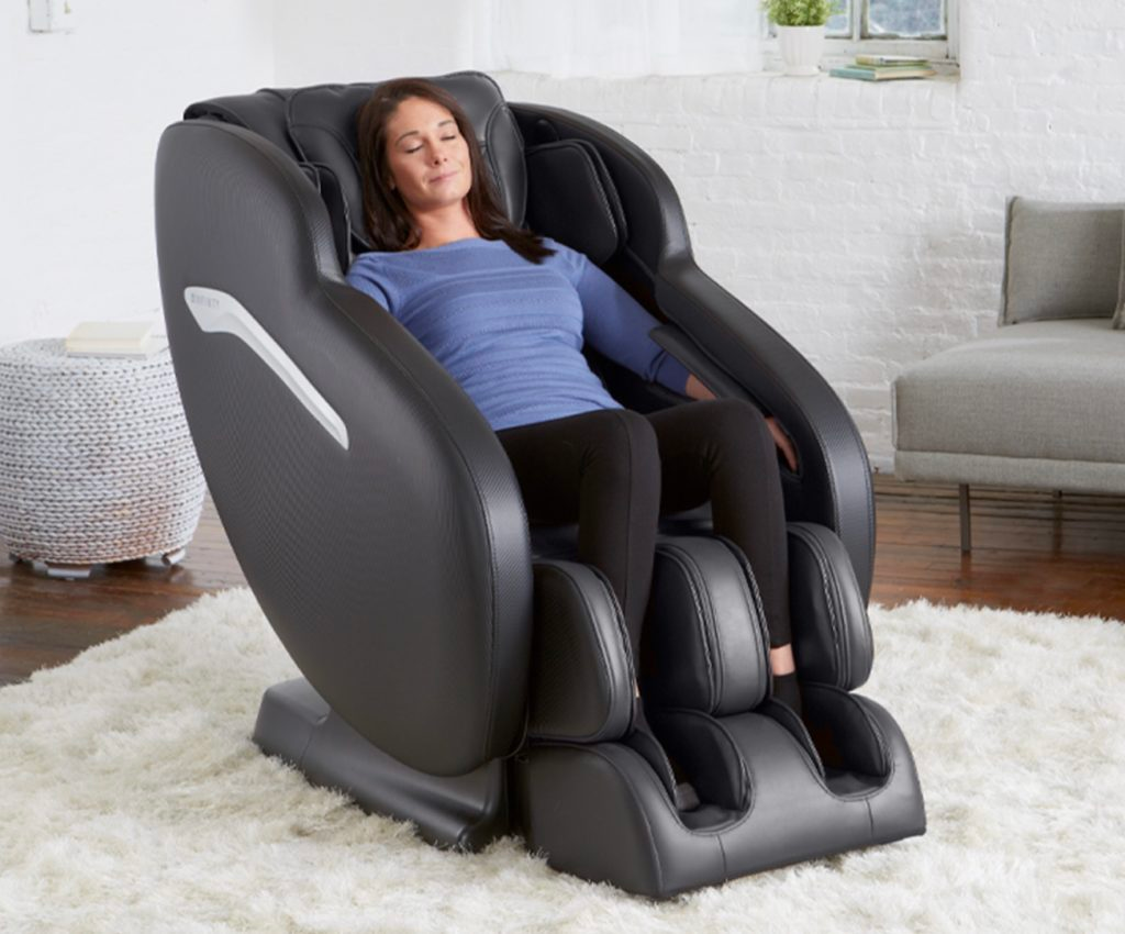 woman in blue shirt and black pants relaxing in an Infinity Aura massage chair