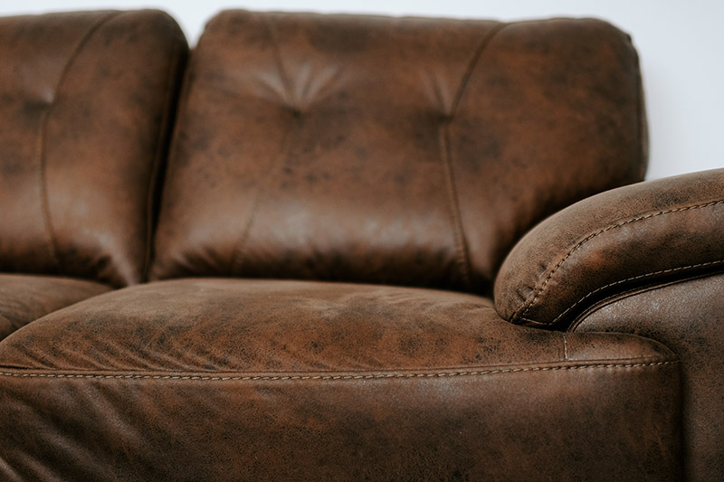 one side of slightly worn leather sofa