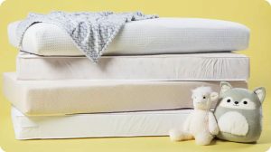 stack-of-crib-mattresses-with-blanket-and-toys